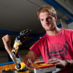 Sam Cameron, engineering student from the University of Waikato, with the robotic arm he built, Hamilton, Waikato, New Zealand, Thursday 1 December 2011.  Photo: Stephen Barker/Barker Photography.  ©The University of Waikato